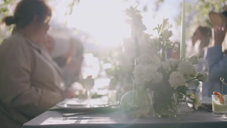 friends-lunch-in-garden-in-sunny-summer-day-marry-women-are-having-dinner-in-nature